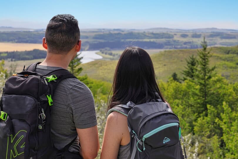 Couple hiking and overlooking the hillside at Rockland Park by Brookfield Residential in Calgary, AB