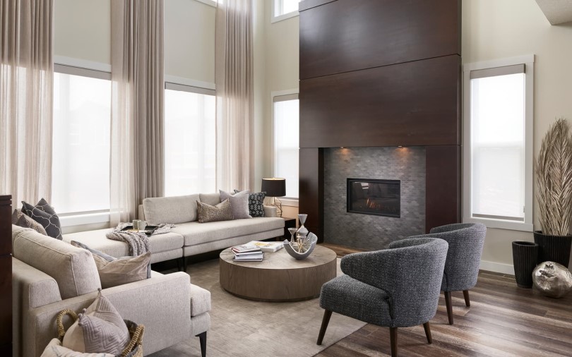 Living room with fireplace in Savona 2 at Cranstons Riverstone in Calgary, AB