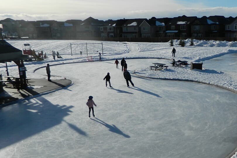 View of skaters on an ice rink at Century Hall by Brookfield Residential in Calgary, AB
