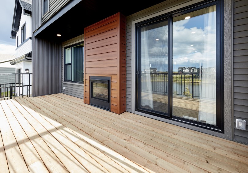 Outdoor deck with double-sided fireplace at Hudson in Chappelle Gardens in Edmonton, AB