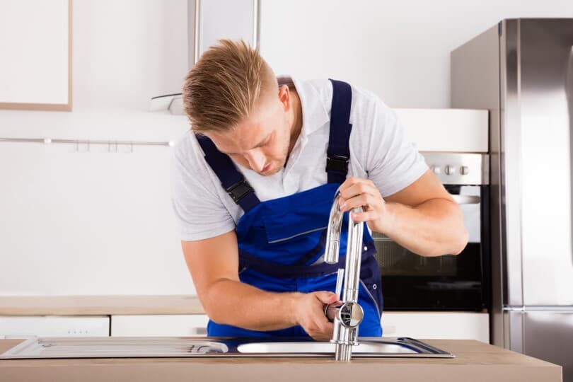 Man replacing a kitchen faucet