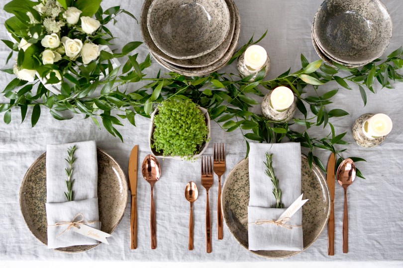 Holiday table setting with linen napkins and rose gold cutlery
