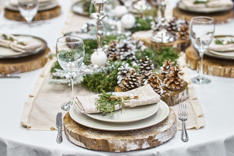 Winter table setting with birch chargers and snowy pinecones