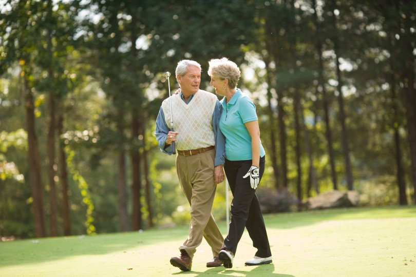 Older couple walking on a golf course