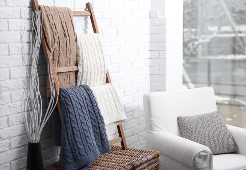 Knitted blankets on a wooden ladder