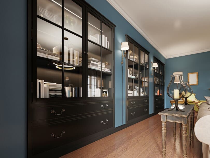 Black built ins in a living room with teal walls