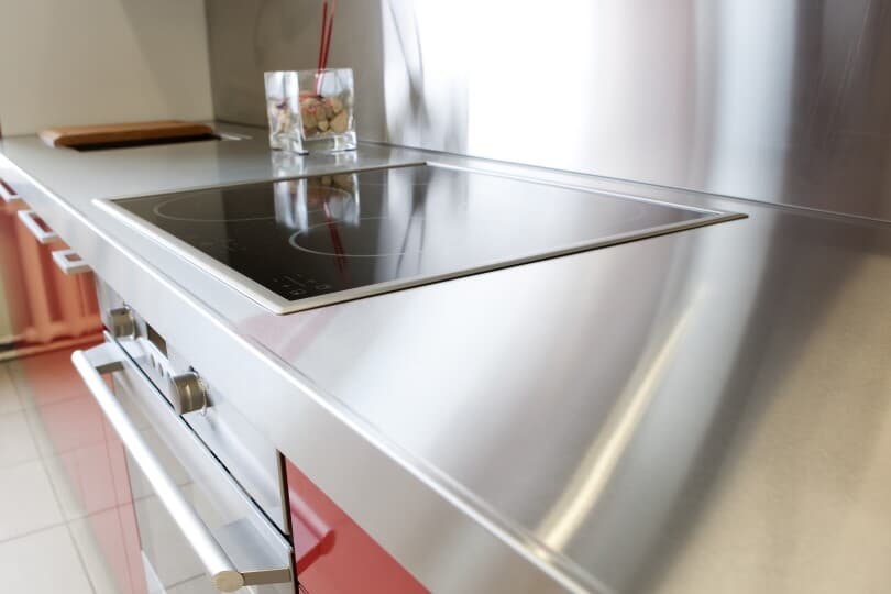 Stainless steel countertop in a kitchen with red cabinets