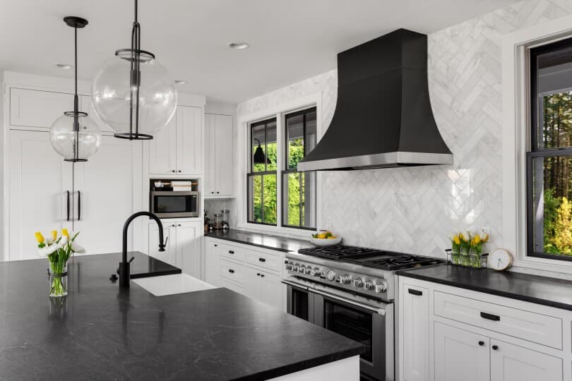 White kitchen with dark soapstone countertops and modern fixtures