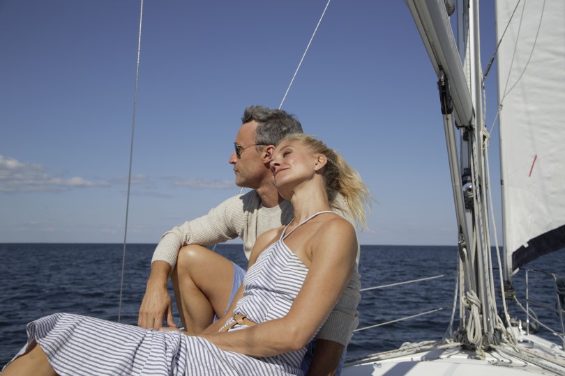 Couple relaxing on a sailboat on the water