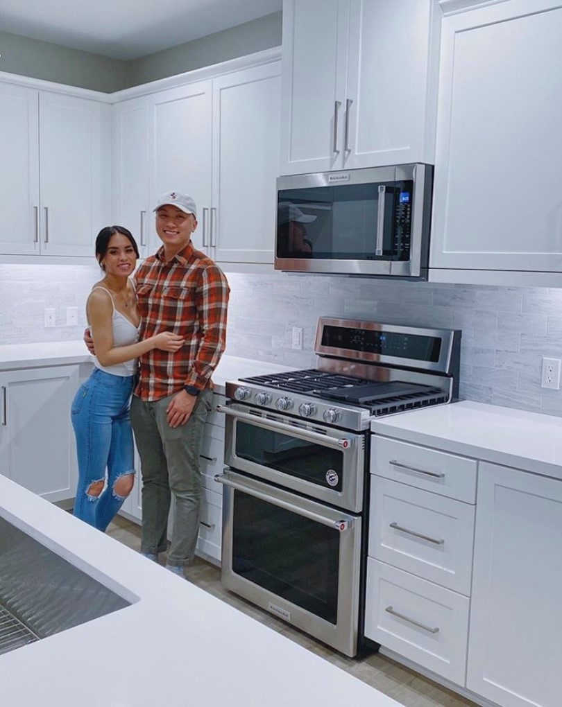 Happy homeowners in their bright white kitchen of their new Brookfield Residential SoCal home