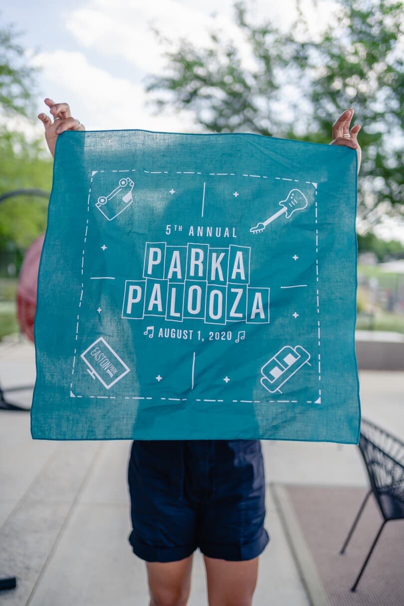 Woman holding turquoise Parkapalooza bandana at Easton Park in Austin, TX